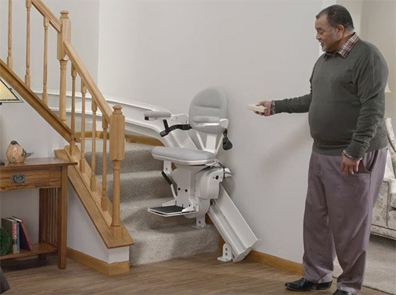 Man calling The Bruno Elite Curved stairlift downstairs